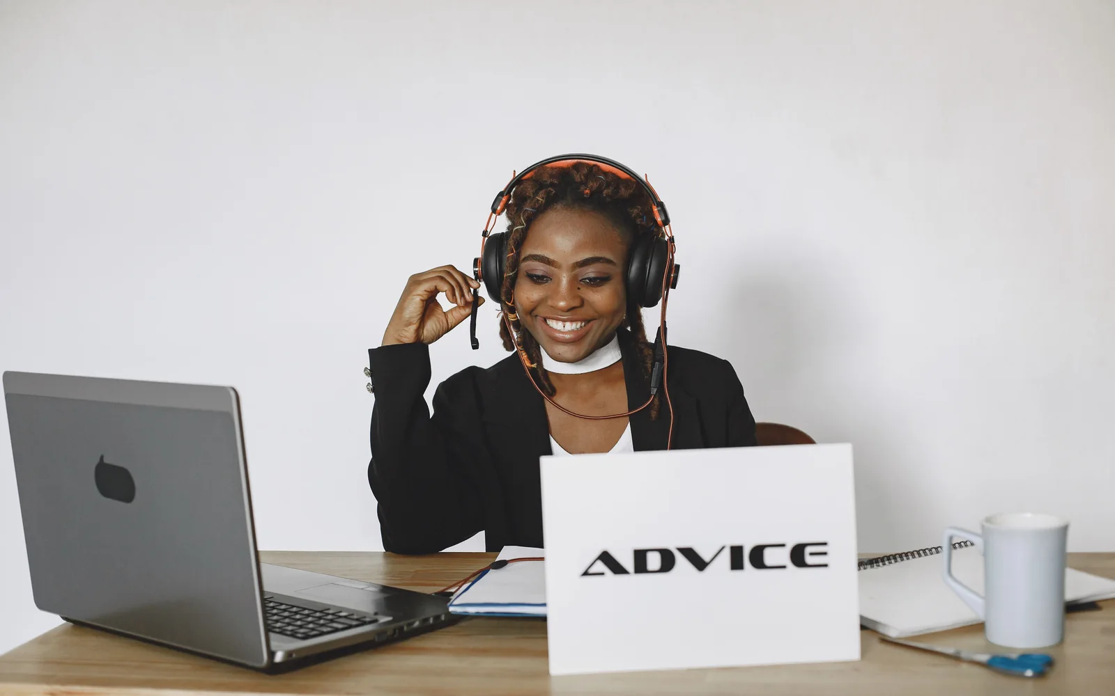 An agent working with laptop and headphones