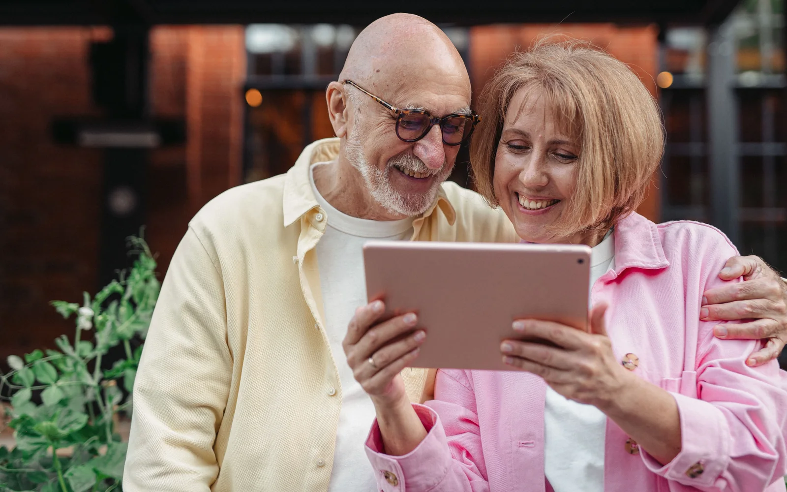 A senior couple smiling while using a tablet together